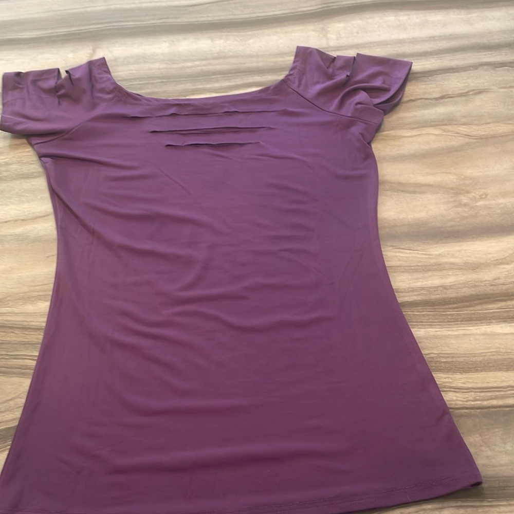 Rich purple color top with cutouts on top of shoulders and neckline.